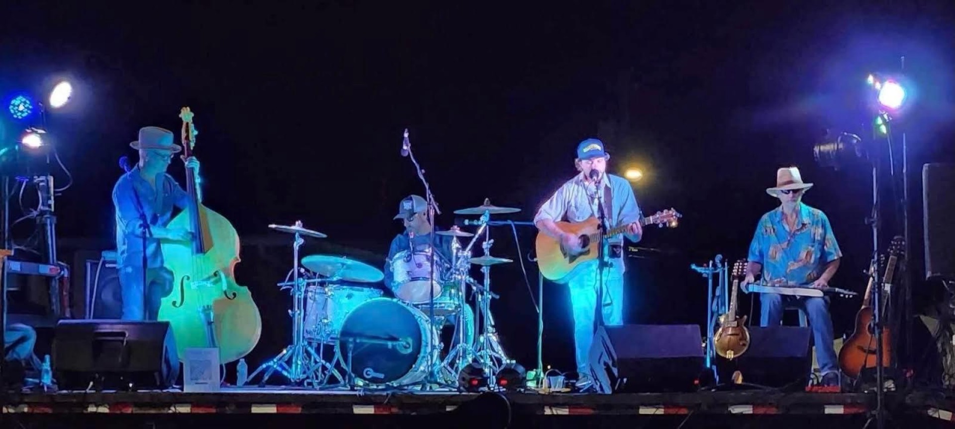 JayR Brink Band performing on stage, playing guitar, drums, and a variety of other instruments.