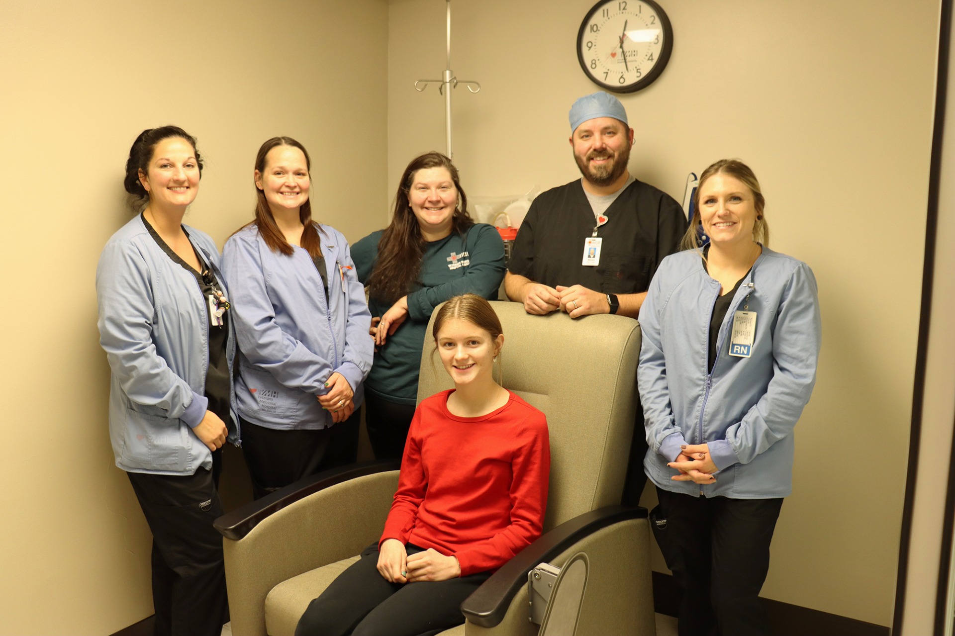 Veterans Memorial Hospital team member Shawn Blake helping a patient at a Pain Clinic with other staff members.