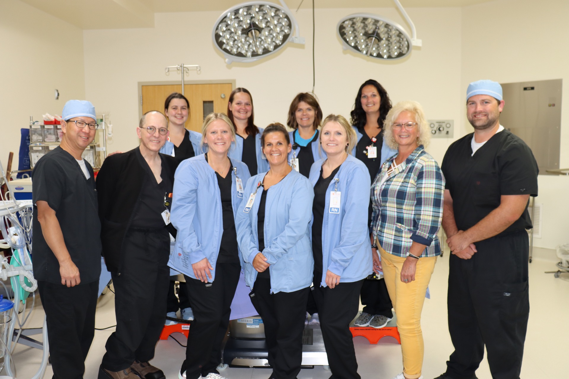 VMH surgery staff and surgeons grouped together in a surgery room.